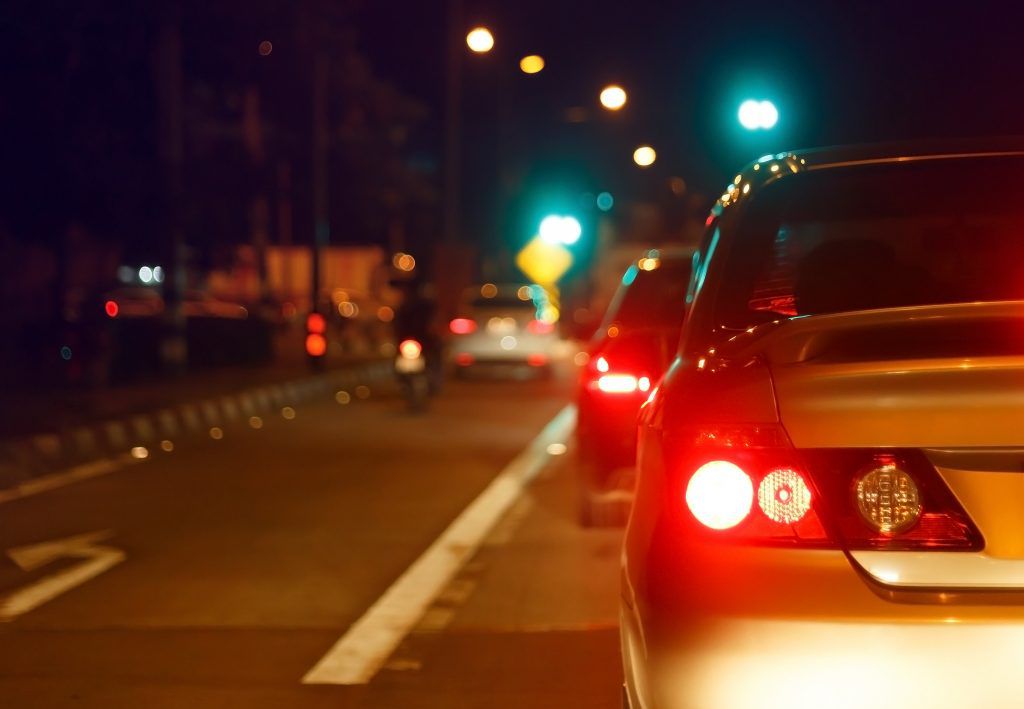 Brake lights on a car driving in the dark