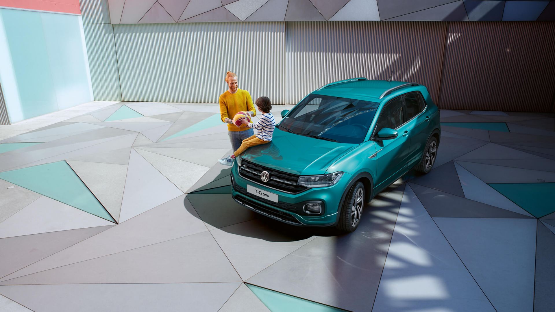 child sat on bonnet of vw t cross with an adult standing interacting with them