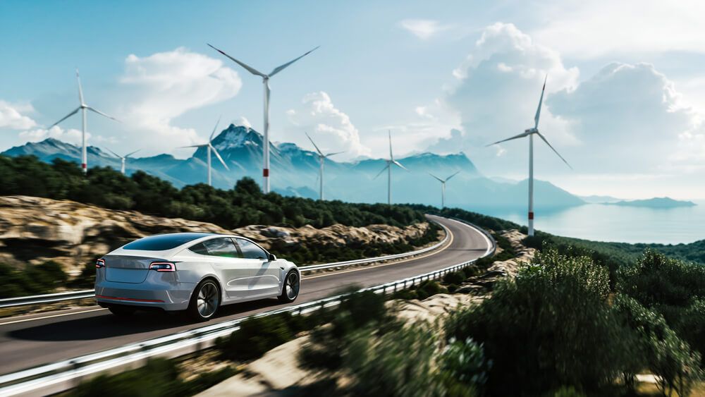 car driving past wind turbines