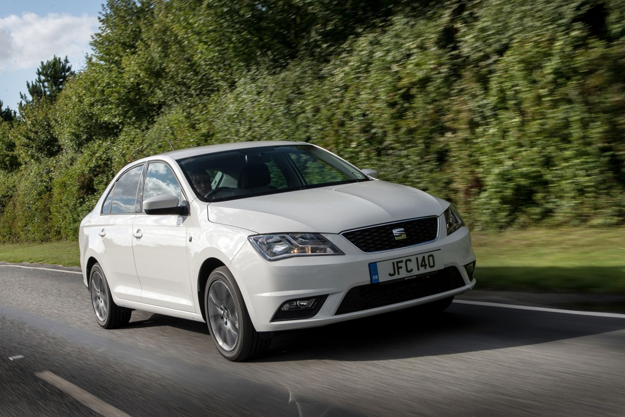 Front view of a white SEAT Toledo driving down the road