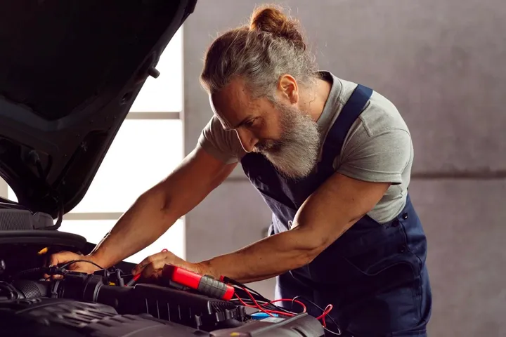 Man servicing the engine on a car